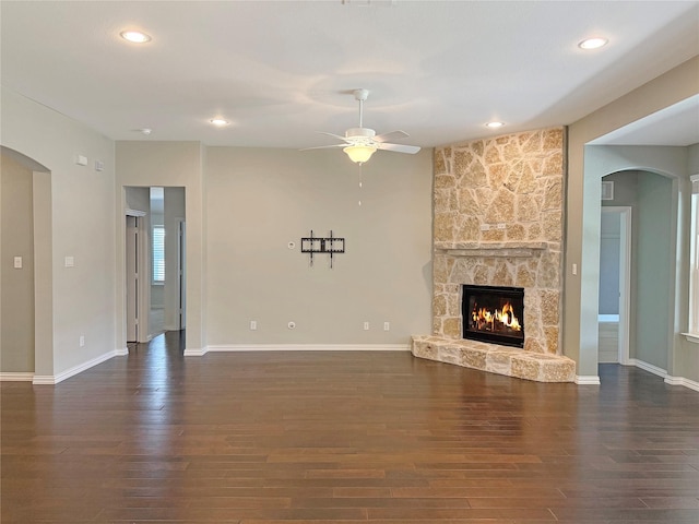 1129 Berrydale Dr, Northlake, TX 76226 - unfurnished living room featuring arched walkways, a ceiling fan, dark wood-type flooring, a stone fireplace, and recessed lighting