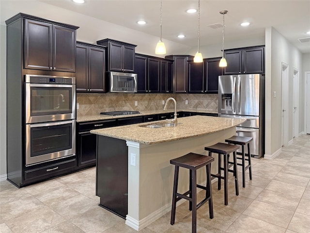 1129 Berrydale Dr, Northlake, TX 76226 - kitchen featuring stainless steel appliances, light stone countertops, tasteful backsplash, an island with sink, and a breakfast bar