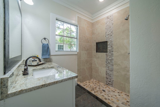 1504 E Rosedale St, Fort Worth, TX 76104 - bathroom featuring tiled shower, vanity, and a textured wall