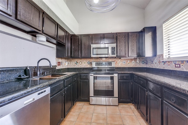 2314 Ember Lee Dr, Garland, TX 75040 - kitchen featuring stainless steel appliances, light tile patterned floors, tasteful backsplash, and dark brown cabinetry
