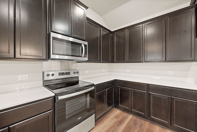 812 13th St, Plano, TX 75074 - kitchen with stainless steel appliances, light wood finished floors, light countertops, dark brown cabinets, and lofted ceiling