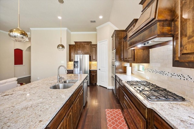 632 Fishback Cir, Plano, TX 75074 - kitchen featuring stainless steel appliances, ornamental molding, light stone counters, custom range hood, and dark wood finished floors