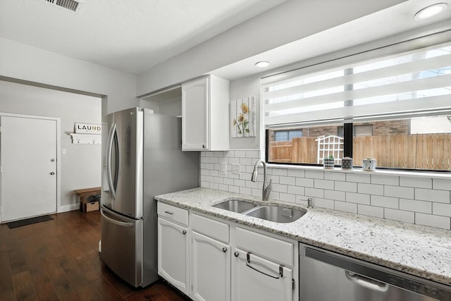 1227 Eaton Ln, Grapevine, TX 76051 - kitchen featuring stainless steel appliances, white cabinetry, tasteful backsplash, dark wood-type flooring, and light stone countertops