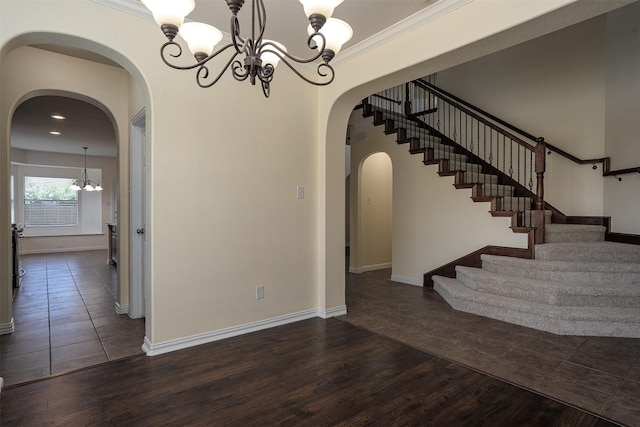 1220 Berkeley Dr, Burleson, TX 76028 - unfurnished dining area with a chandelier, stairway, dark wood-style flooring, arched walkways, and crown molding
