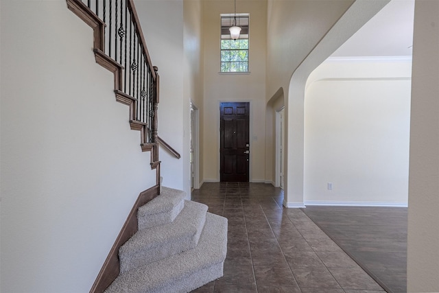 1220 Berkeley Dr, Burleson, TX 76028 - entryway with arched walkways, a high ceiling, and stairs