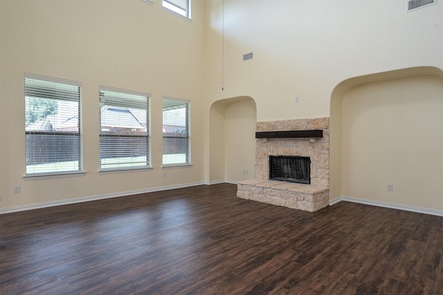 1220 Berkeley Dr, Burleson, TX 76028 - unfurnished living room featuring dark wood finished floors, a towering ceiling, and a fireplace