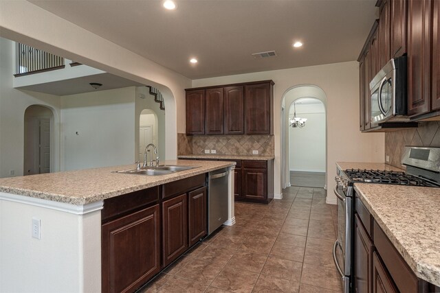 1220 Berkeley Dr, Burleson, TX 76028 - kitchen with appliances with stainless steel finishes, arched walkways, decorative backsplash, light countertops, and recessed lighting