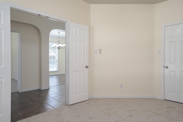 1220 Berkeley Dr, Burleson, TX 76028 - tiled spare room featuring carpet flooring, a chandelier, and arched walkways