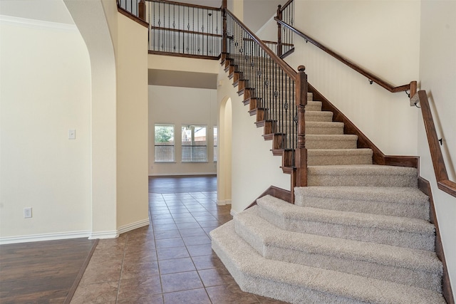 1220 Berkeley Dr, Burleson, TX 76028 - stairway with arched walkways, a towering ceiling, ornamental molding, and wood finished floors
