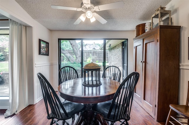 5205 Shady Springs Ct, Arlington, TX 76017 - dining space featuring a textured ceiling, dark wood-style floors, wainscoting, and a ceiling fan