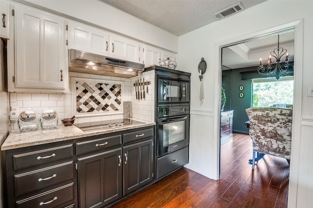 5205 Shady Springs Ct, Arlington, TX 76017 - kitchen with black appliances, under cabinet range hood, a textured ceiling, dark wood-type flooring, and white cabinetry