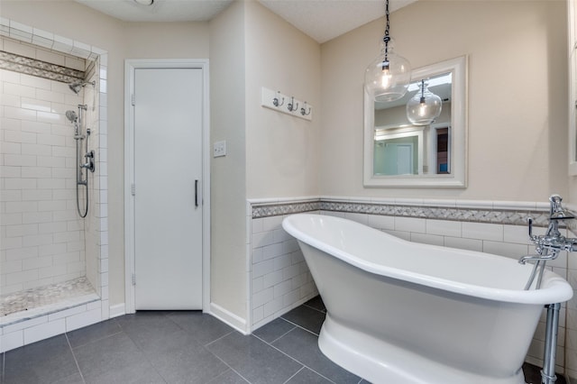 5205 Shady Springs Ct, Arlington, TX 76017 - full bathroom featuring a freestanding bath, tiled shower, a wainscoted wall, tile patterned floors, and tile walls