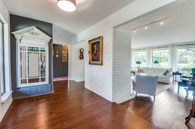 5205 Shady Springs Ct, Arlington, TX 76017 - hall with wood-type flooring, a textured ceiling, vaulted ceiling, and brick wall