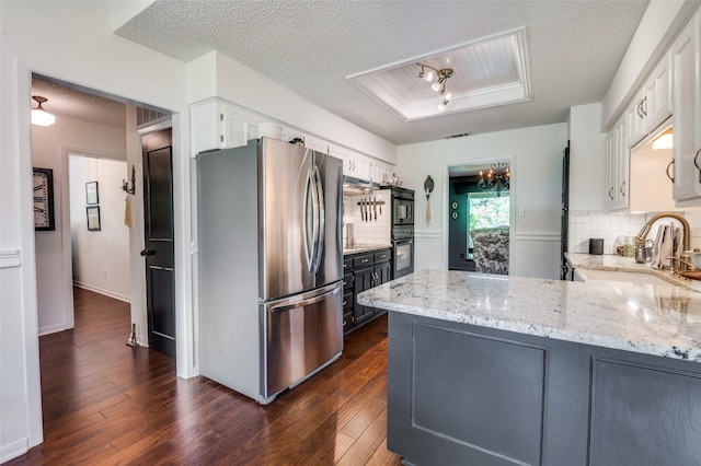 5205 Shady Springs Ct, Arlington, TX 76017 - kitchen featuring freestanding refrigerator, a textured ceiling, a peninsula, white cabinets, and light stone counters