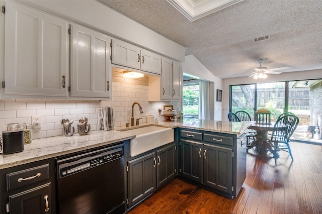 5205 Shady Springs Ct, Arlington, TX 76017 - kitchen featuring black dishwasher, a textured ceiling, a peninsula, backsplash, and vaulted ceiling