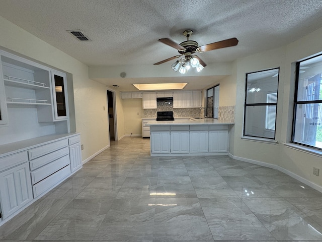 510 Betsy Ross Dr, Arlington, TX 76002 - kitchen with backsplash, light countertops, a peninsula, a ceiling fan, and black range with electric cooktop