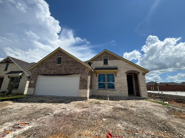 2017 Kelva Dr, Haslet, TX 76052 - french country inspired facade featuring brick siding, a garage, stone siding, and driveway
