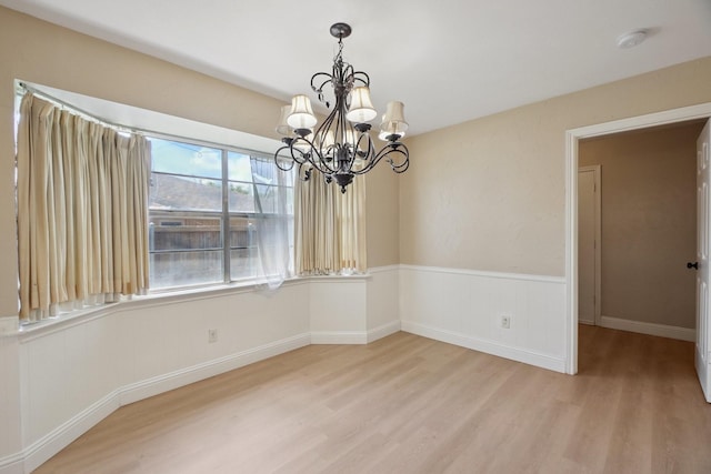 2709 S Hillbrier Cir, Plano, TX 75075 - empty room featuring light wood-style floors, a chandelier, a smoke detector, and a wainscoted wall