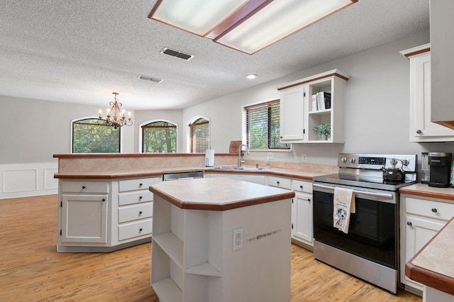 143 Shady Woods Ln, Denison, TX 75021 - kitchen featuring stainless steel appliances, open shelves, a peninsula, light countertops, and a chandelier
