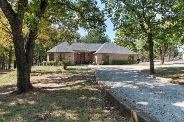 143 Shady Woods Ln, Denison, TX 75021 - view of front of house featuring a chimney, brick siding, and curved driveway