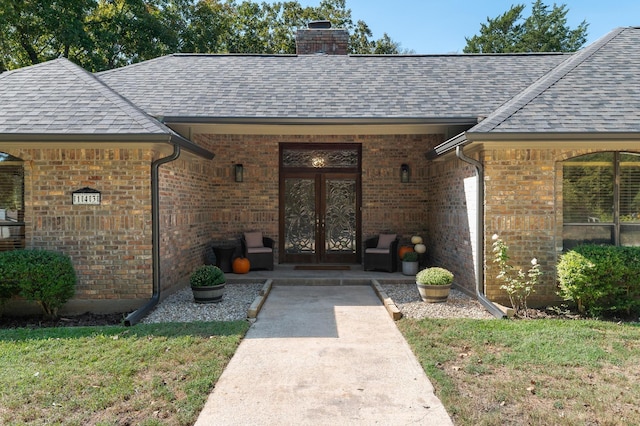 143 Shady Woods Ln, Denison, TX 75021 - entrance to property featuring french doors, brick siding, roof with shingles, and a chimney