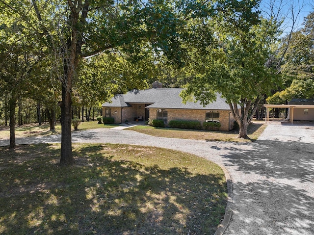 143 Shady Woods Ln, Denison, TX 75021 - view of front of house featuring curved driveway, a chimney, and a shingled roof