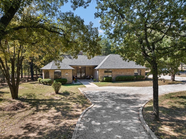 143 Shady Woods Ln, Denison, TX 75021 - view of front facade featuring asphalt driveway, brick siding, and roof with shingles