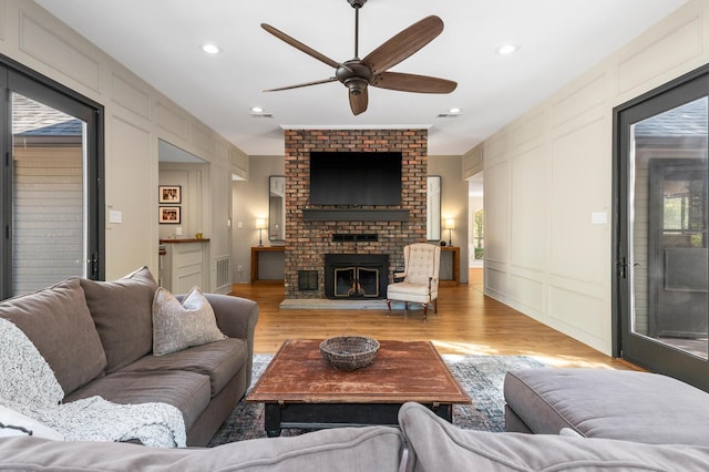 143 Shady Woods Ln, Denison, TX 75021 - living room with a decorative wall, a ceiling fan, light wood finished floors, plenty of natural light, and a fireplace