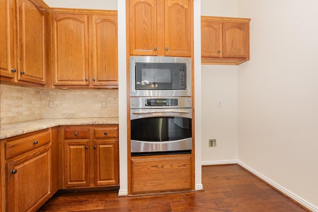 2248 Amy Ln, Plano, TX 75074 - kitchen with stainless steel appliances, tasteful backsplash, dark wood-style flooring, light stone counters, and brown cabinets