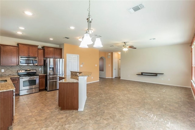 6600 Cascade Dr, Waco, TX 76712 - kitchen featuring stainless steel appliances, arched walkways, recessed lighting, tasteful backsplash, and decorative light fixtures