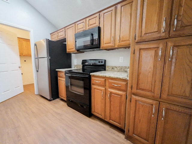 820 Via Madonna, Mesquite, TX 75150 - kitchen with black appliances, lofted ceiling, light wood finished floors, brown cabinets, and light stone counters
