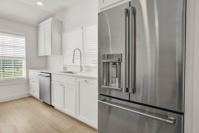 301 E Wall St, Grapevine, TX 76051 - kitchen featuring stainless steel appliances, light countertops, white cabinetry, light wood-style floors, and recessed lighting