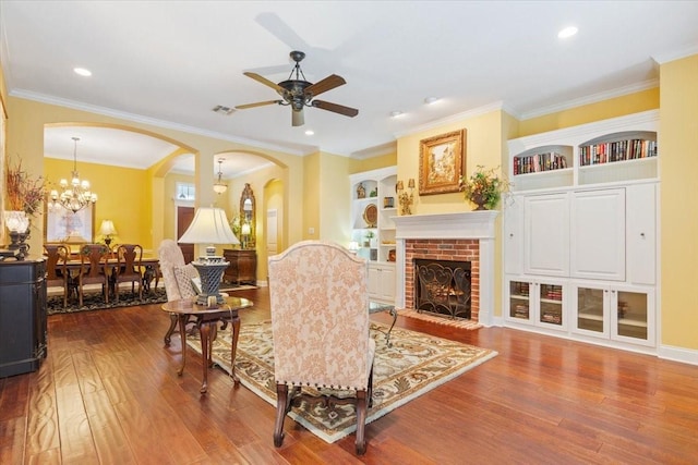 1313 Windstone Dr, Waco, TX 76712 - living area with wood finished floors, arched walkways, ceiling fan, a brick fireplace, and built in features