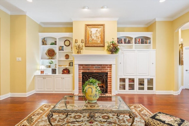 1313 Windstone Dr, Waco, TX 76712 - living room featuring arched walkways, wood finished floors, a brick fireplace, ornamental molding, and built in features