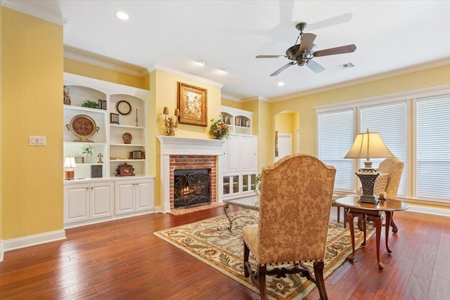 1313 Windstone Dr, Waco, TX 76712 - living area featuring hardwood / wood-style flooring, ceiling fan, ornamental molding, a brick fireplace, and built in shelves