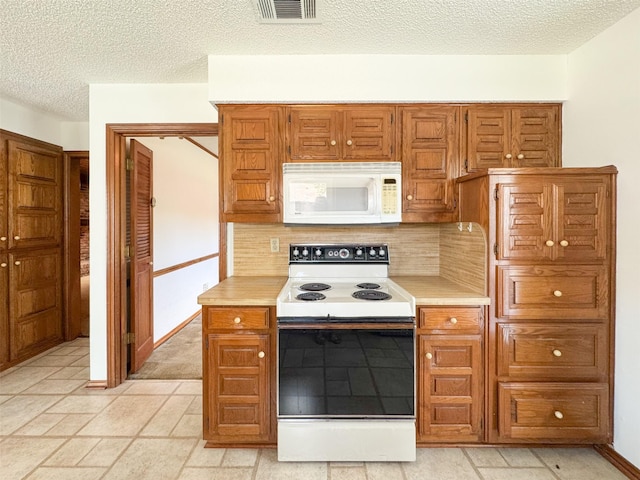 2006 Cornwall Ln, Sachse, TX 75048 - kitchen with white appliances, light countertops, decorative backsplash, brown cabinetry, and a textured ceiling