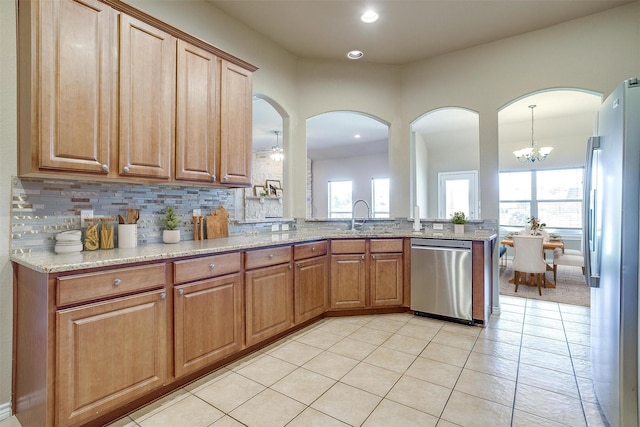 1201 Claire Ct, Burleson, TX 76028 - kitchen featuring appliances with stainless steel finishes, light stone countertops, plenty of natural light, light tile patterned floors, and recessed lighting