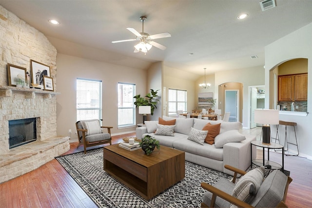 1201 Claire Ct, Burleson, TX 76028 - living area with ceiling fan, a fireplace, light wood-type flooring, arched walkways, and recessed lighting
