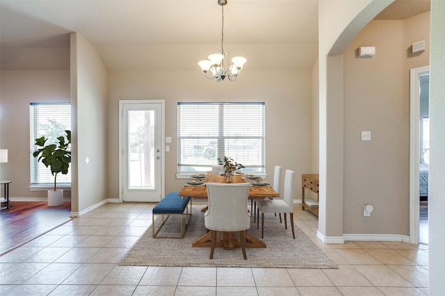 1201 Claire Ct, Burleson, TX 76028 - dining room featuring plenty of natural light, arched walkways, light tile patterned floors, and a chandelier