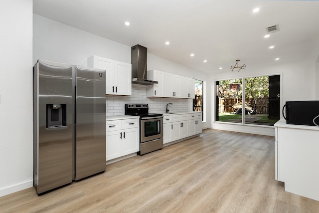 4942 Thunder Rd, Dallas, TX 75244 - kitchen with appliances with stainless steel finishes, wall chimney range hood, light countertops, white cabinets, and light wood finished floors