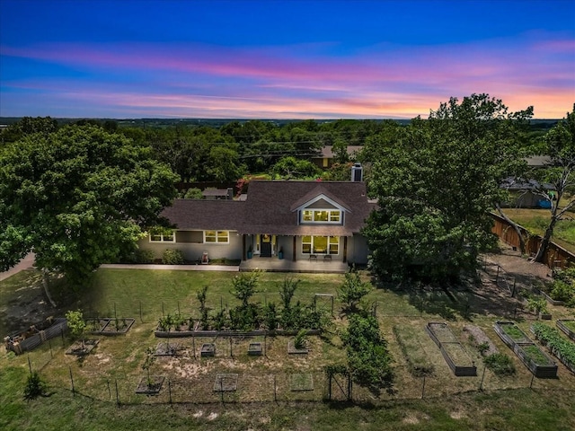 612 W Park Ave, Weatherford, TX 76086 - back of property at dusk featuring a vegetable garden