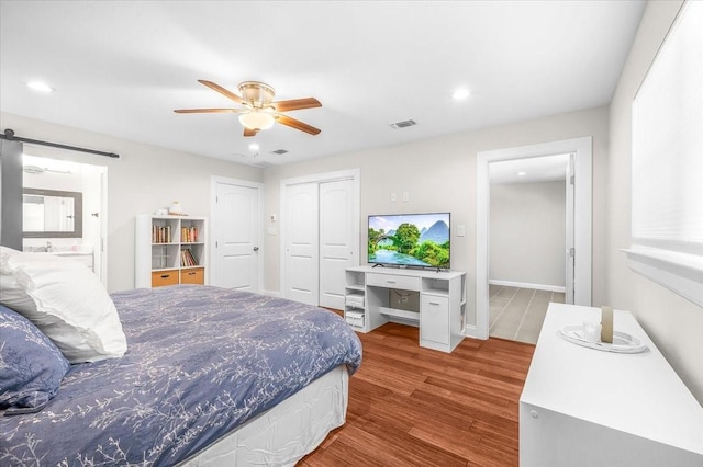 612 W Park Ave, Weatherford, TX 76086 - bedroom with wood finished floors, a closet, recessed lighting, a ceiling fan, and a barn door