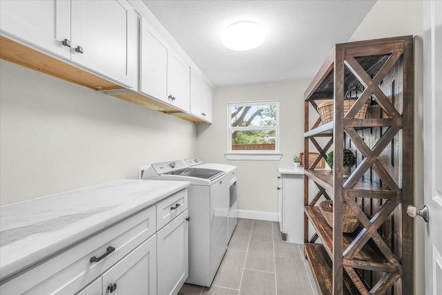 612 W Park Ave, Weatherford, TX 76086 - laundry area featuring independent washer and dryer, cabinet space, and light tile patterned flooring