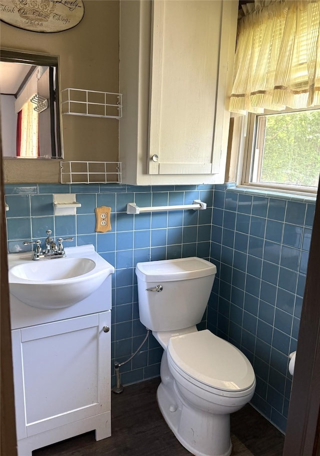 2015 E 5th St, Tyler, TX 75701 - half bath with vanity, wood finished floors, a wainscoted wall, and tile walls