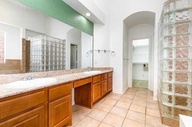 2742 Hidden Knoll Trl, Frisco, TX 75034 - bathroom featuring double vanity, walk in shower, tile patterned flooring, and a textured wall