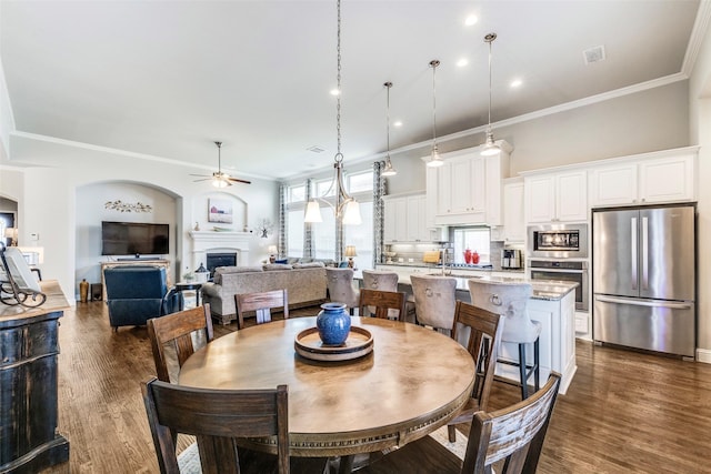 3300 Western Bluff Ct, Mansfield, TX 76063 - dining space featuring a ceiling fan, crown molding, a fireplace, dark wood finished floors, and recessed lighting