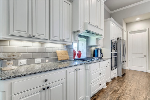 3300 Western Bluff Ct, Mansfield, TX 76063 - kitchen with appliances with stainless steel finishes, crown molding, white cabinetry, wood finished floors, and decorative backsplash