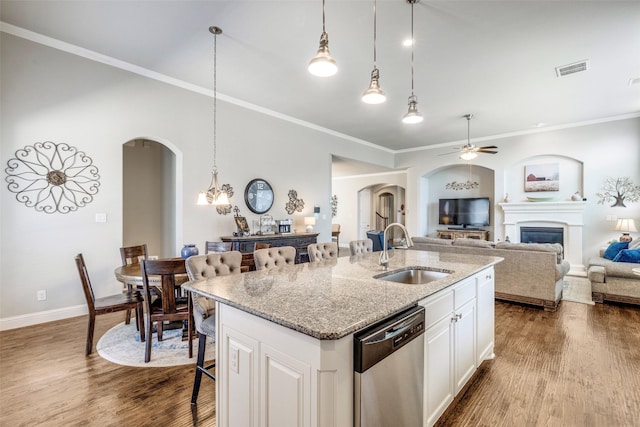 3300 Western Bluff Ct, Mansfield, TX 76063 - kitchen featuring arched walkways, stainless steel dishwasher, a ceiling fan, an island with sink, and ornamental molding