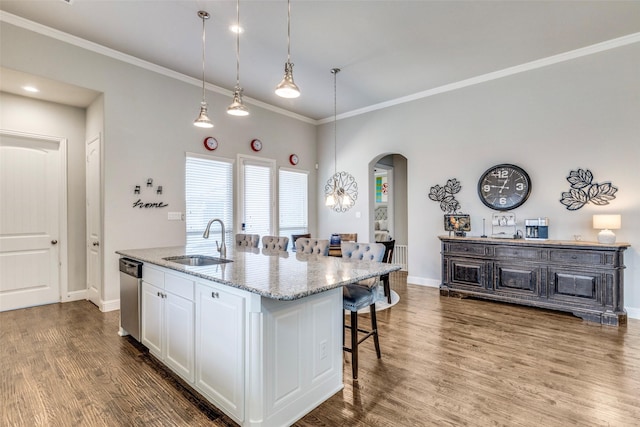 3300 Western Bluff Ct, Mansfield, TX 76063 - kitchen with arched walkways, stainless steel dishwasher, ornamental molding, a breakfast bar, and white cabinetry