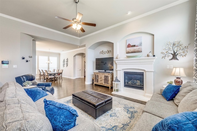 3300 Western Bluff Ct, Mansfield, TX 76063 - living area featuring wood finished floors, ceiling fan, arched walkways, ornamental molding, and a glass covered fireplace